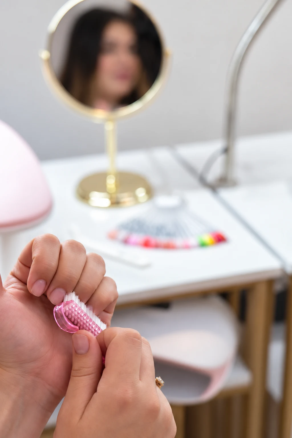 Naturlige negle og en lille rosa neglebørste ved manicurebordet