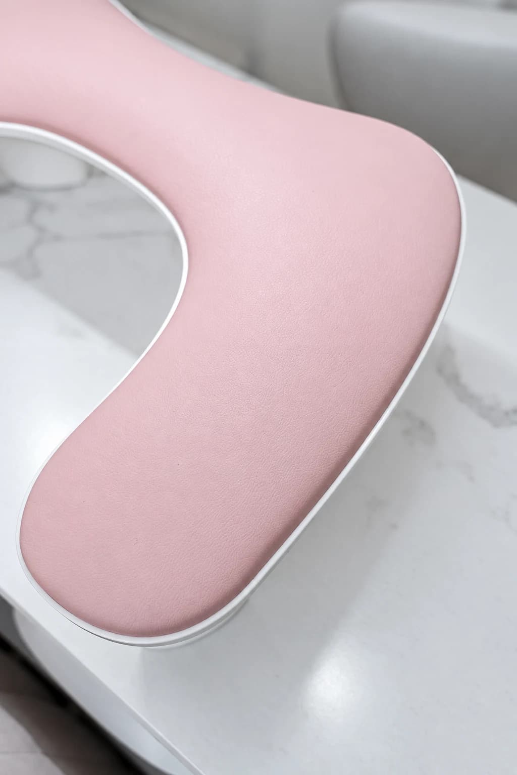 Detalje af en rosa håndstøtte på marmorbordet